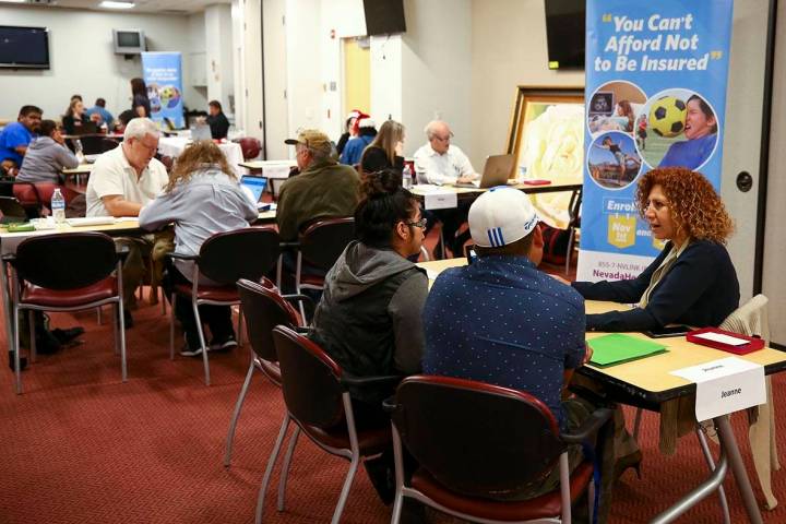 Insurance broker Jeanna Kamo, right, helps a couple sign up for the exchange during an open enr ...