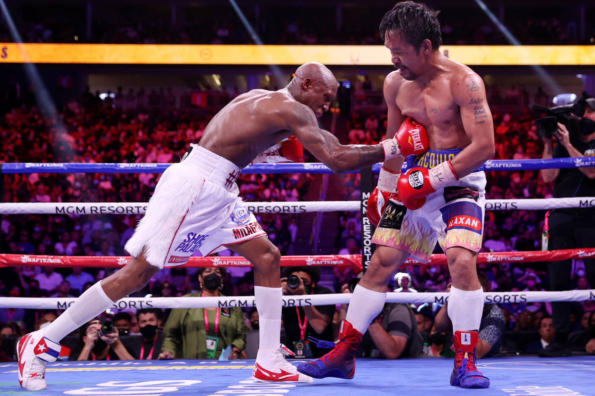 Yordenis Ugas, left, connects a punch against Manny Pacquiao in the eight round of the WBA Worl ...