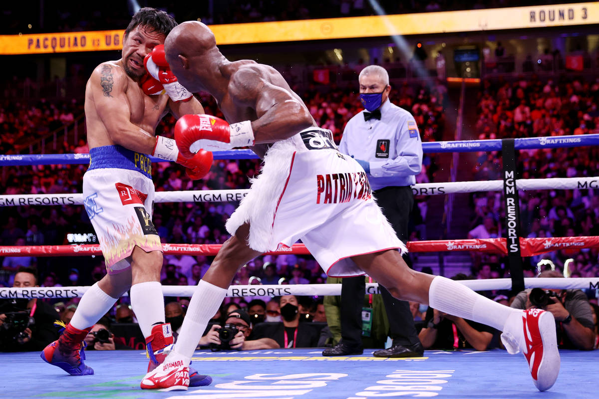 Yordenis Ugas, right, connects a punch against Manny Pacquiao in the third round of the WBA Wor ...