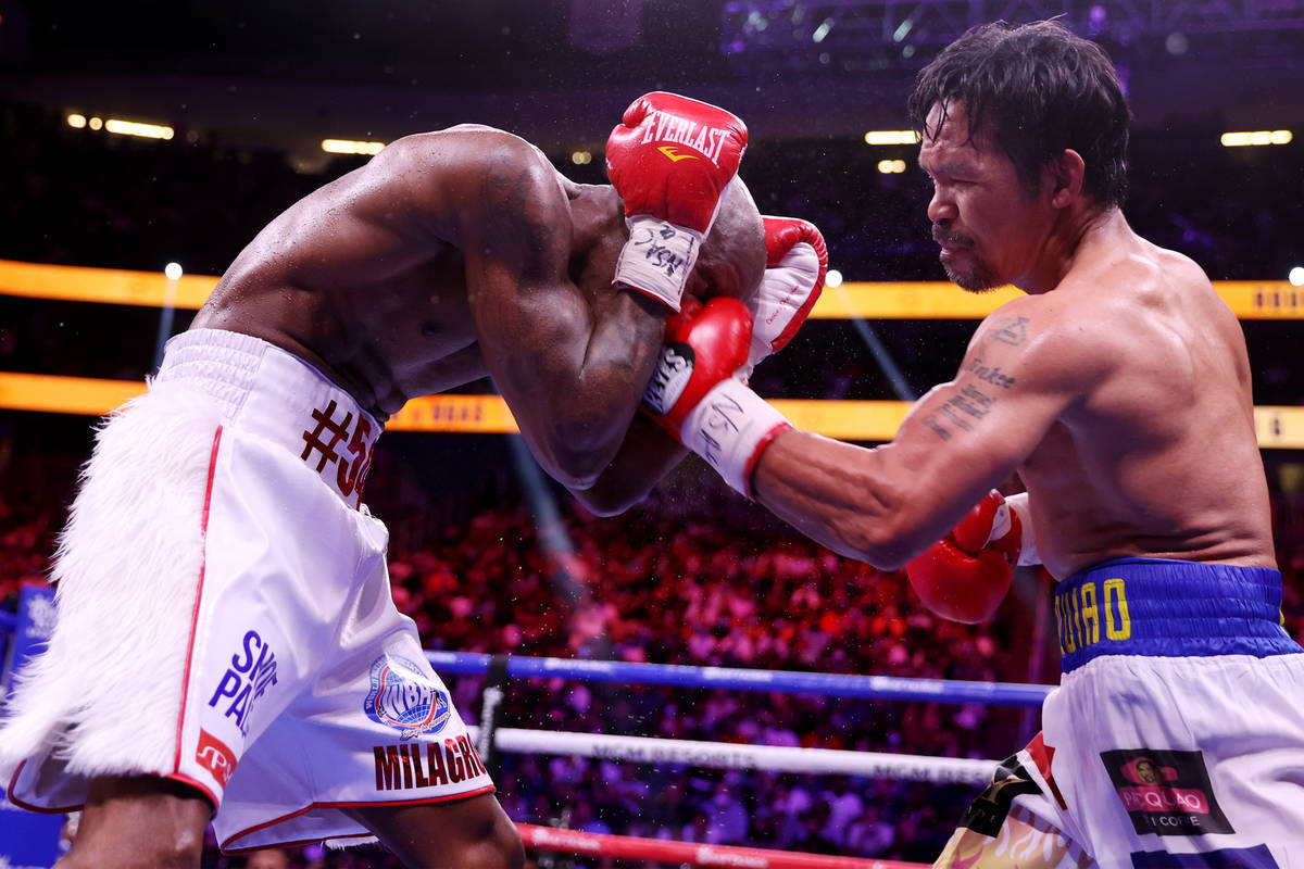 Yordenis Ugas, left, takes a punch from Manny Pacquiao in the sixth round of the WBA World Welt ...