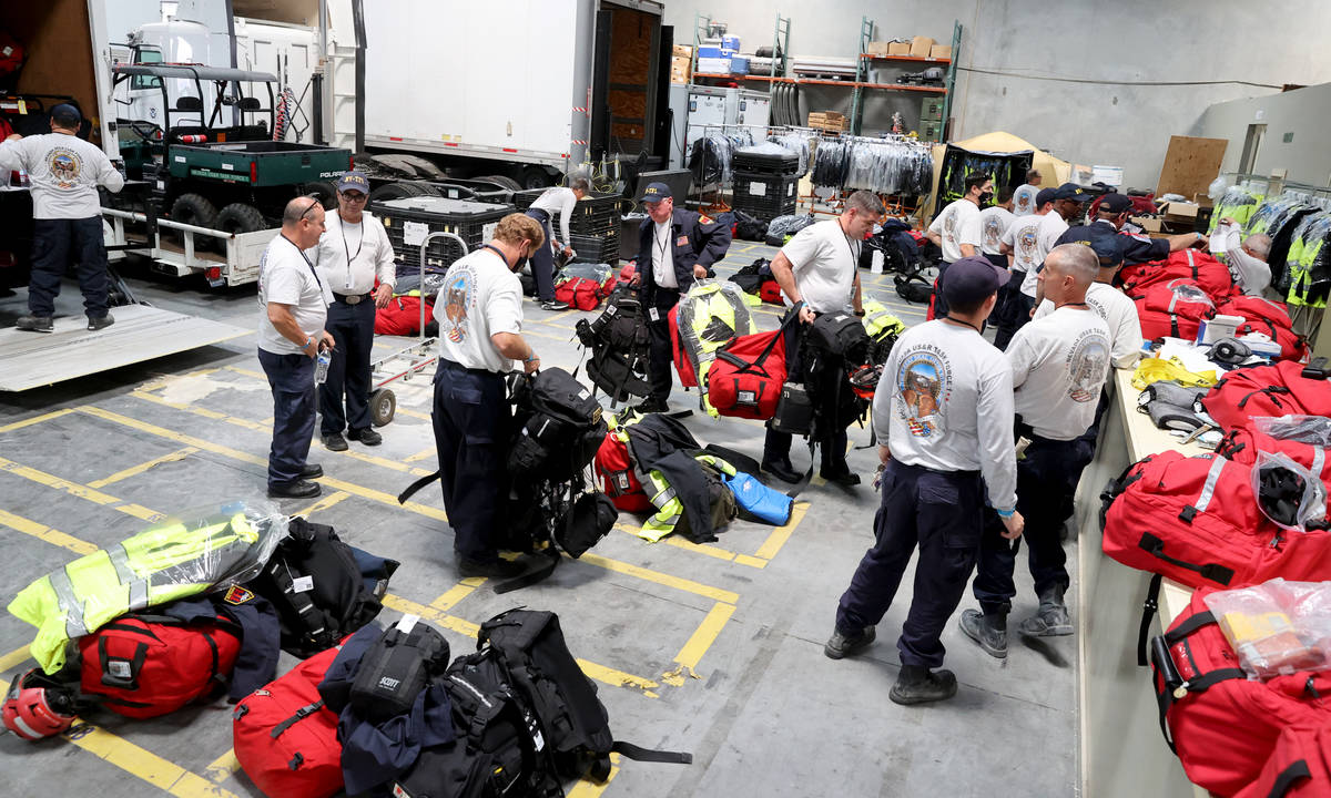 Members of the FEMA Nevada Task Force 1 Urban Search & Rescue team load equipment at their ...