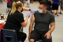 Steve Cancino of Las Vegas, right, receives his second dose of the Moderna COVID-19 vaccine fro ...