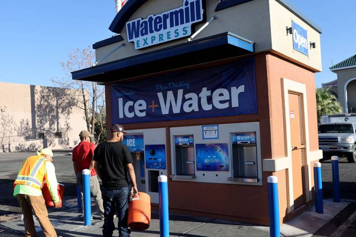 Workers line up for ice at a kiosk on the corner of Smoke Ranch Road and Jones Boulevard in Las ...