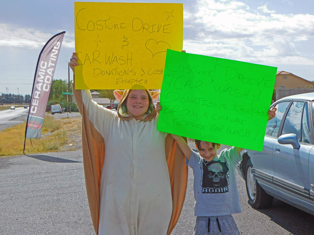 Robin Hebrock/Pahrump Valley Times Hoisting signs into the air, Caden Dragna, right, and Alicia ...