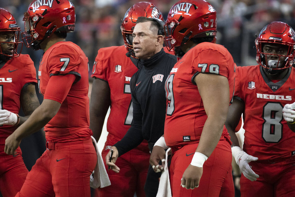 UNLV Rebels head coach Marcus Arroyo, middle, gives direction to his team during a timeout in t ...