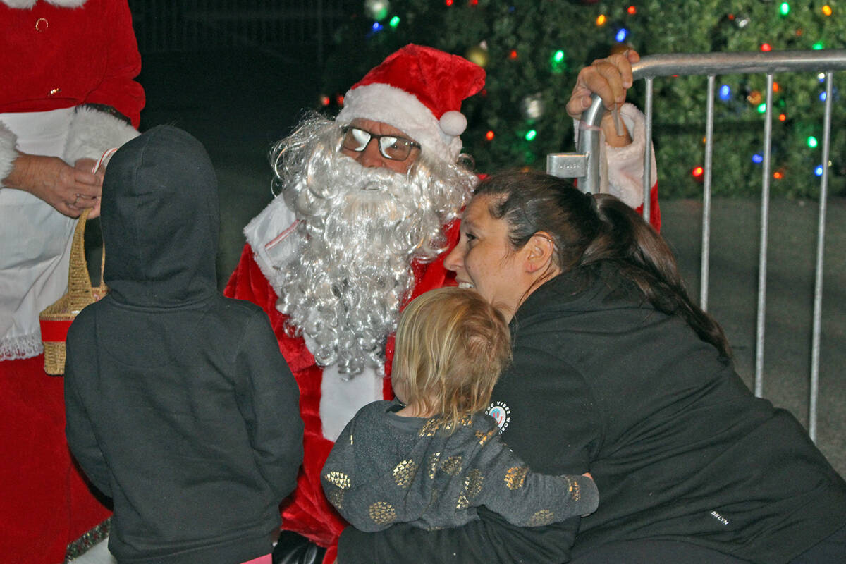 Robin Hebrock/Pahrump Valley Times Jolly old Saint Nick can be seen talking to a couple of youn ...