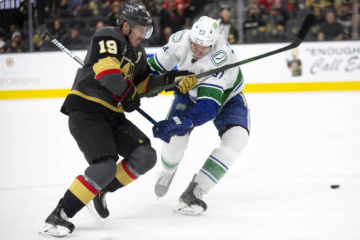 Golden Knights right wing Reilly Smith (19) and Canucks defenseman Tyler Myers (57) compete for ...