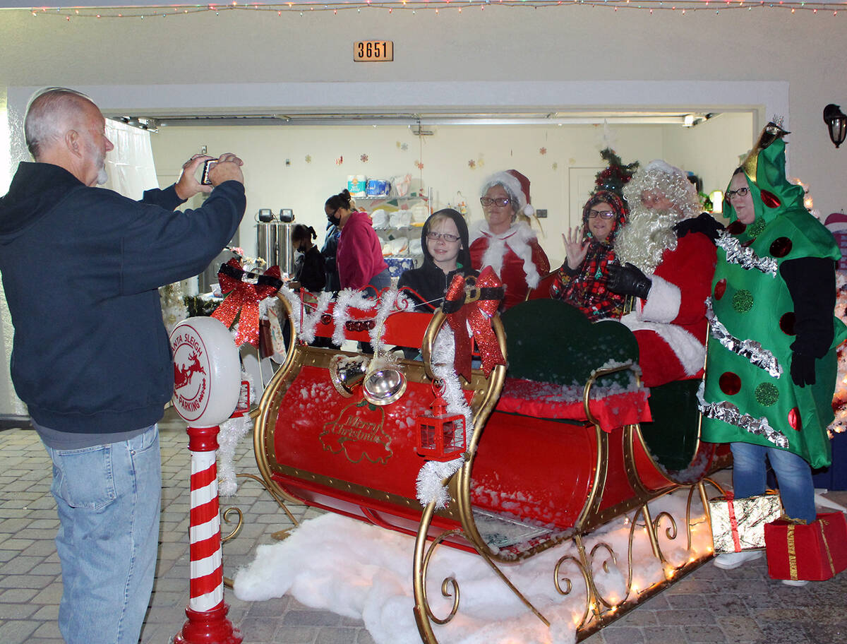 Robin Hebrock/Pahrump Valley Times A local family is seen posing inside a sleigh with Santa, Mr ...