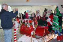 Robin Hebrock/Pahrump Valley Times A local family is seen posing inside a sleigh with Santa, Mr ...