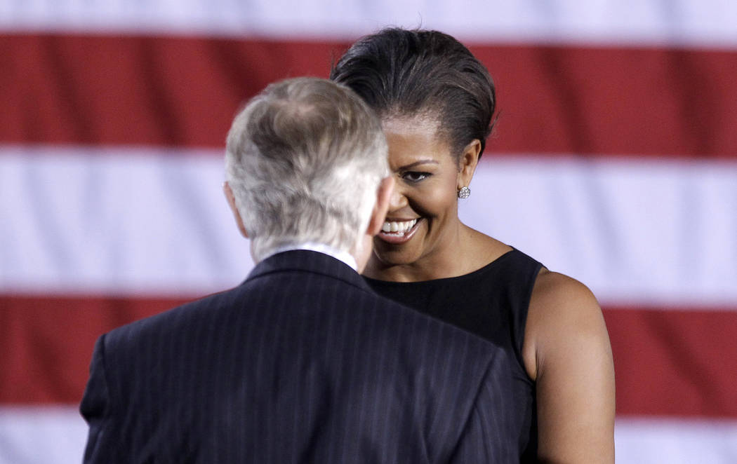 First lady Michelle Obama greets Senate Majority Leader Harry Reid of Nevada during a rally on ...
