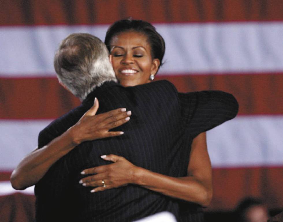First lady Michelle Obama hugs U.S. Sen. Harry Reid, D-Nev., at Canyon Springs High School in N ...