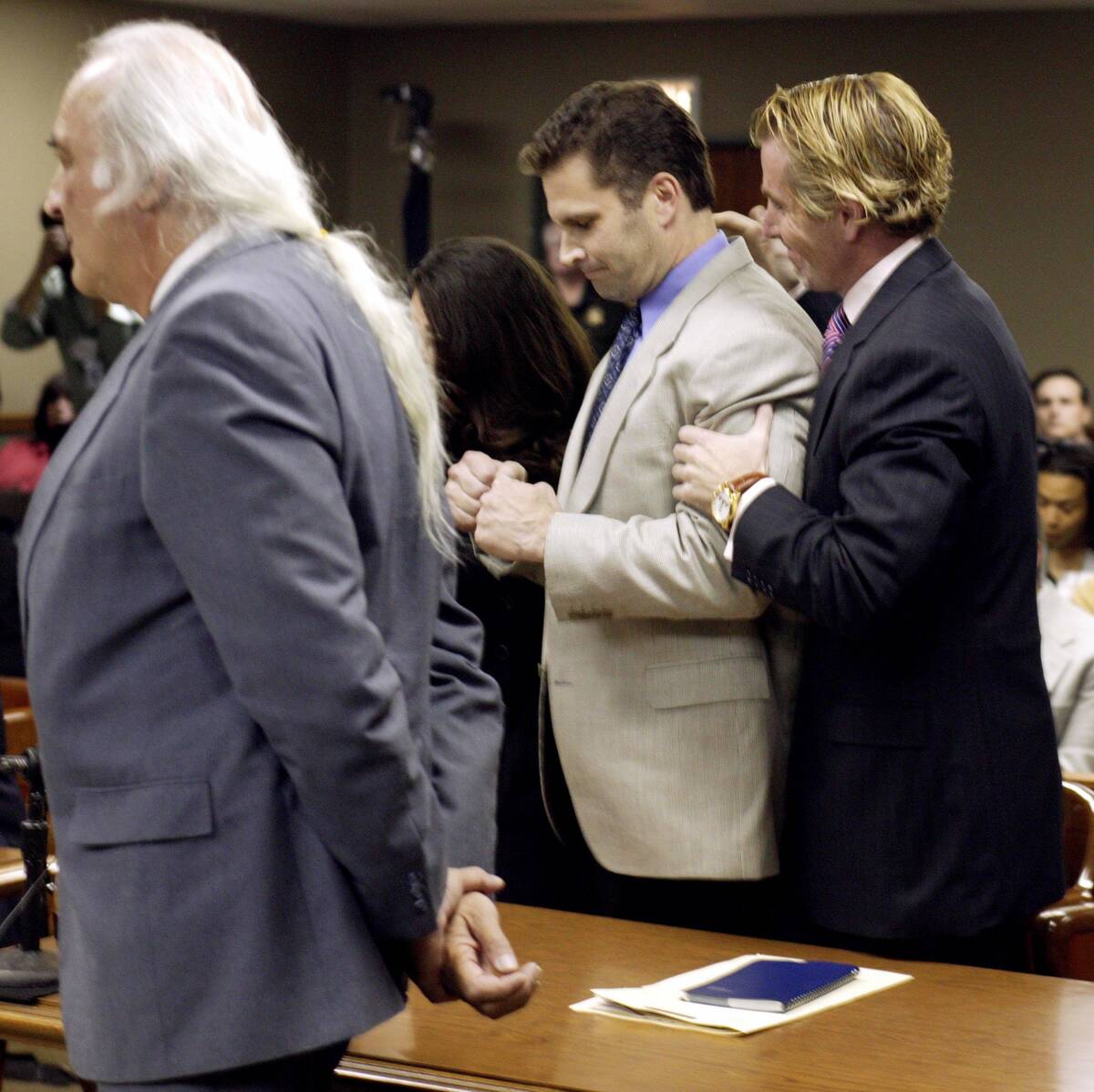 Rick Tabish clutches his fists while being embraced by attorney Joseph Caramagno as his other a ...