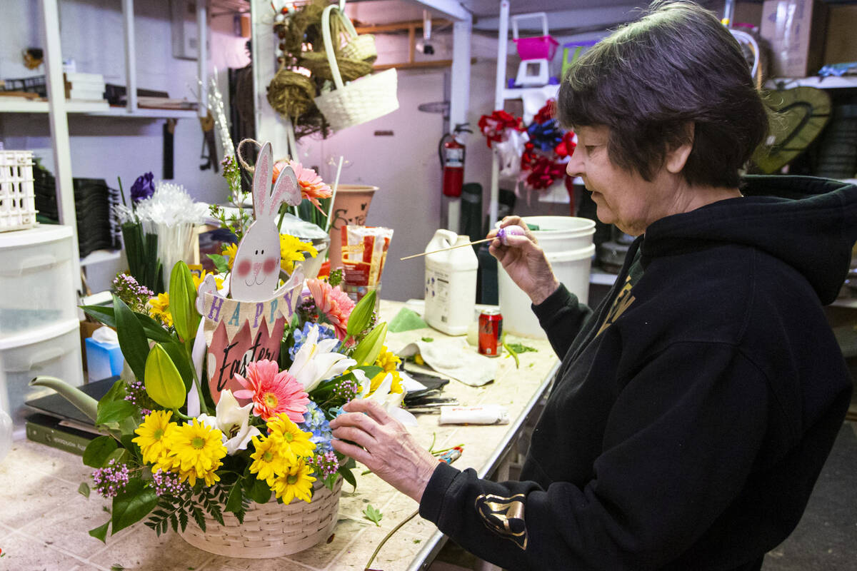 Sue DiBella, co-owner of DiBella Flowers and Gifts, prepares an Easter floral arrangement on Tu ...