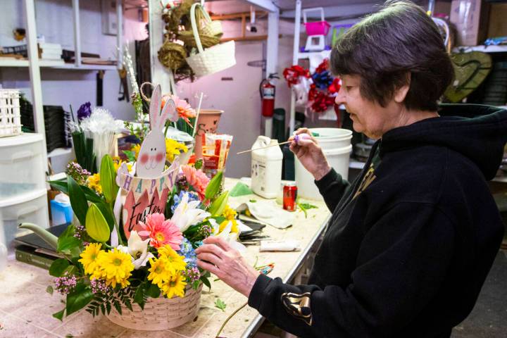 Sue DiBella, co-owner of DiBella Flowers and Gifts, prepares an Easter floral arrangement on Tu ...