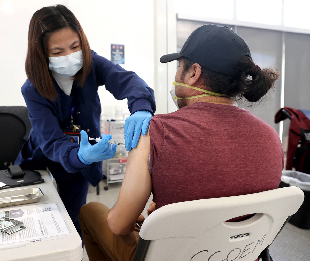 Maria Mendoza gives a shot to Javier De La Torre of Las Vegas at a COVID-19 vaccination station ...