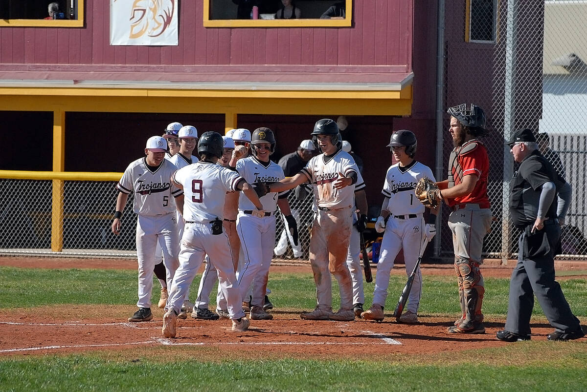Horace Langford Jr./Pahrump Valley Times Colby Tiller (9) reaching home plate to celebrate with ...