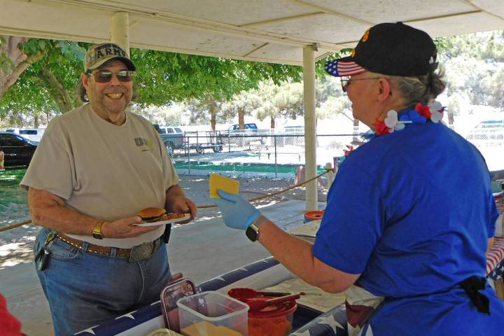 Robin Hebrock/Pahrump Valley Times Local veteran Richard Goldstein, left, is served a slice of ...