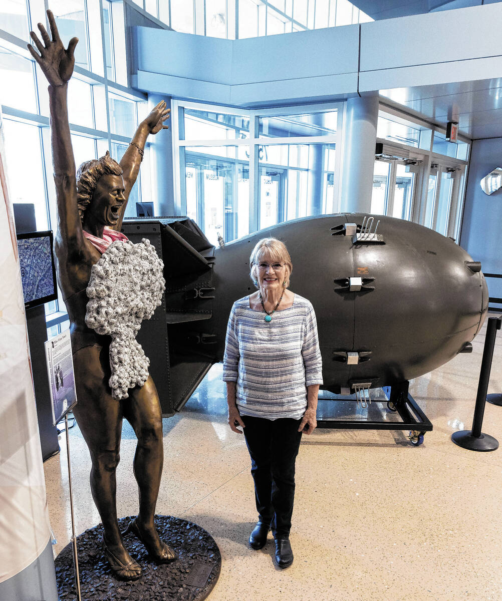 Jeanne Sharp Howerton poses for a photo between the sculpture of "Miss Atom Bomb," le ...