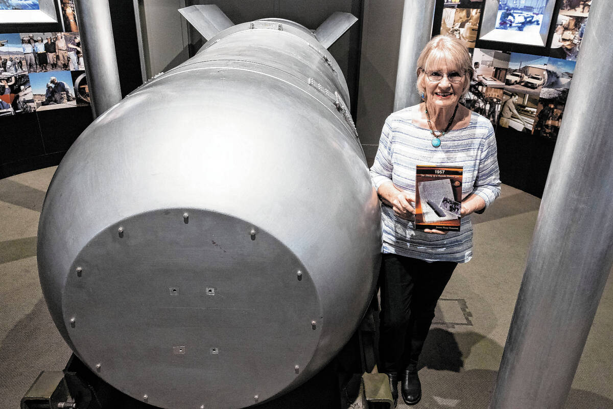 Jeanne Sharp Howerton holds her published book as she poses for a photo next to the casing of B ...