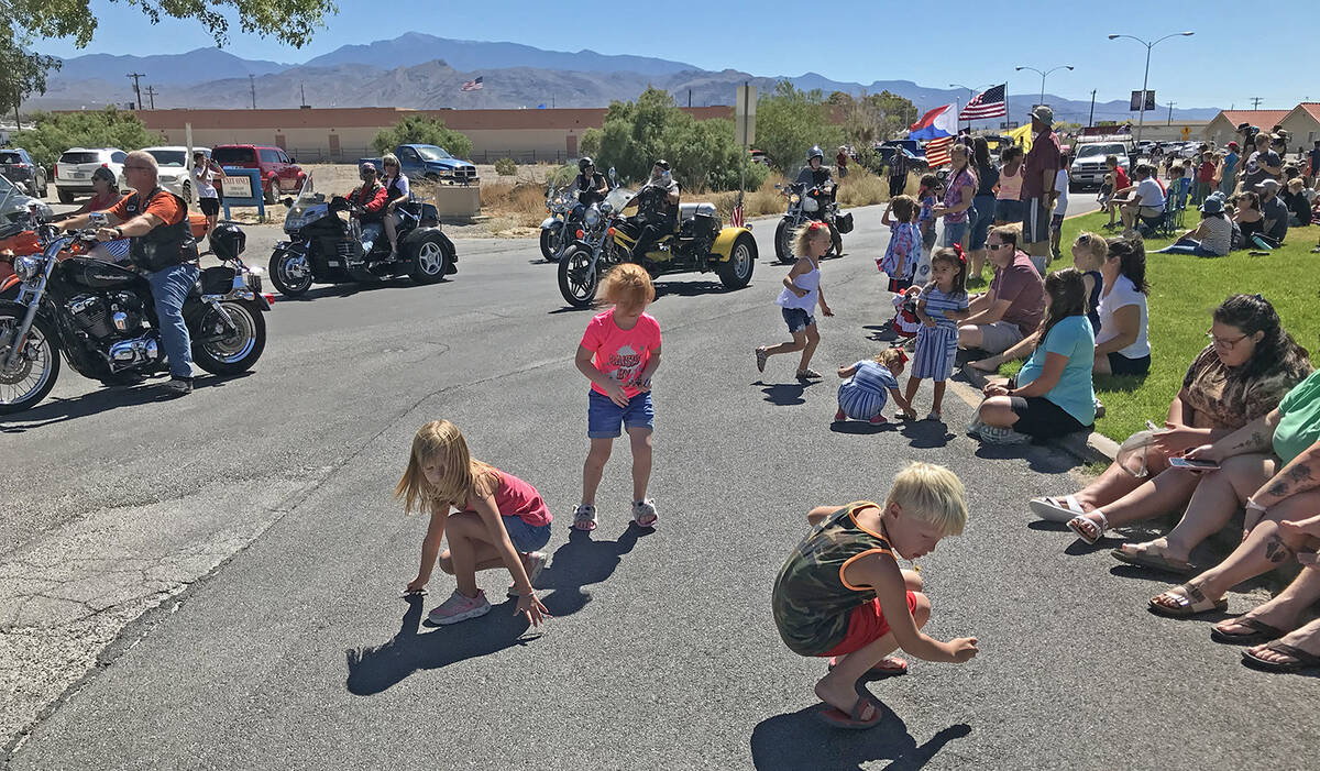 Robin Hebrock/Pahrump Valley Times Rushing into the street, kids gather up candy flung out to t ...