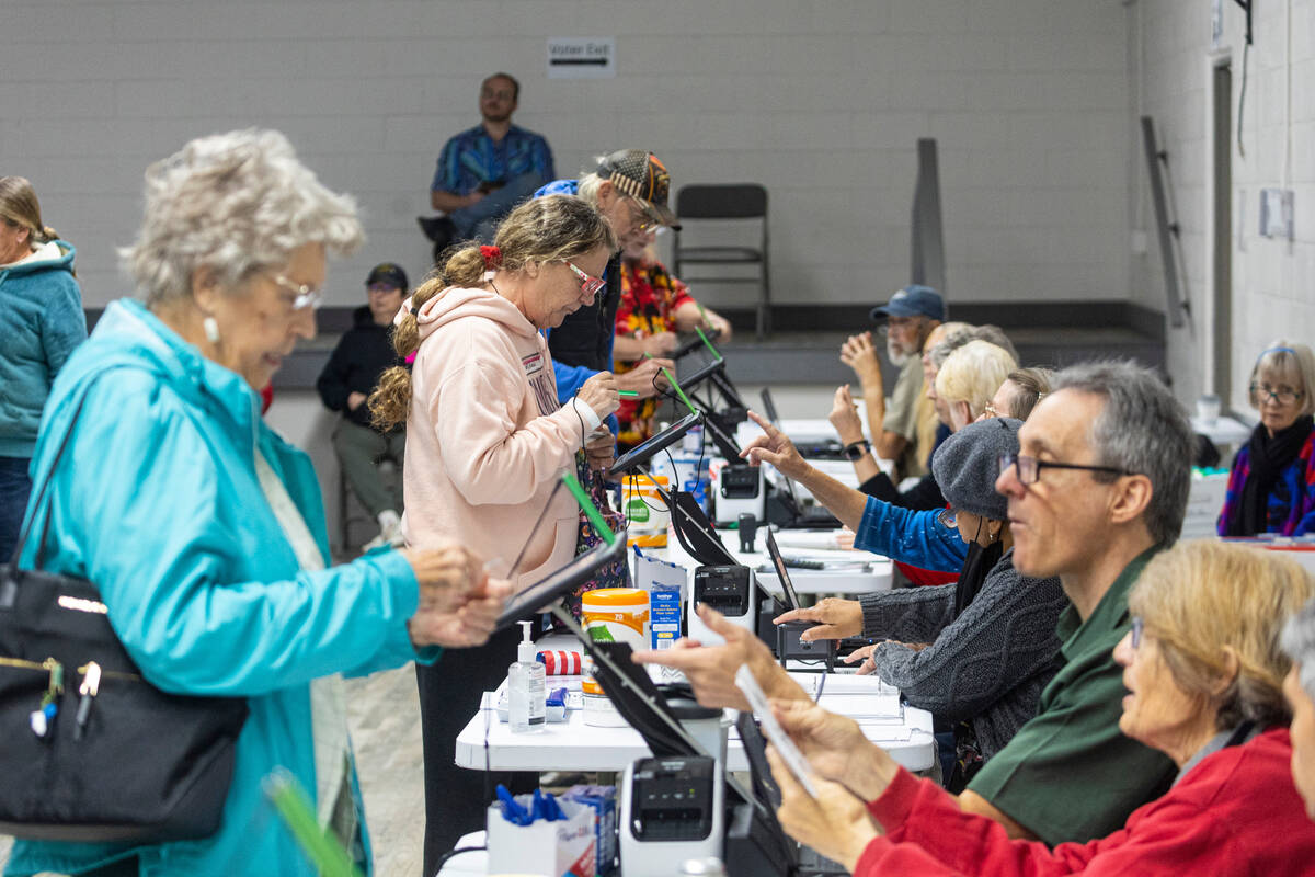 Nye County voters check in with poll workers to cast their ballots on Election Day at Bob Ruud ...