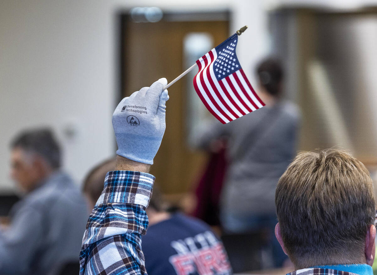 A volunteer waves a flag for ballot marking confirmation as they resume hand counting ballots i ...