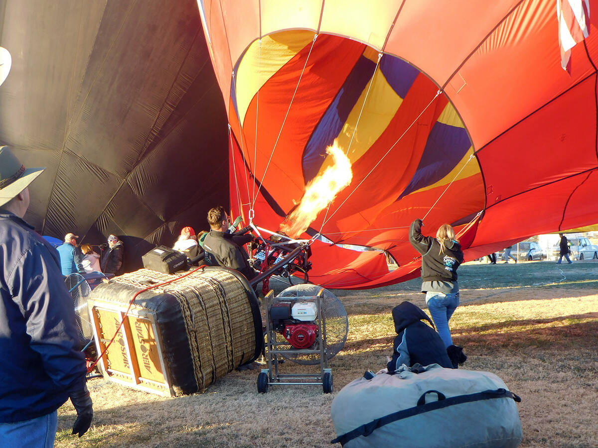 Robin Hebrock/Pahrump Valley Times Balloon crews work with propane burners to inflate the envel ...