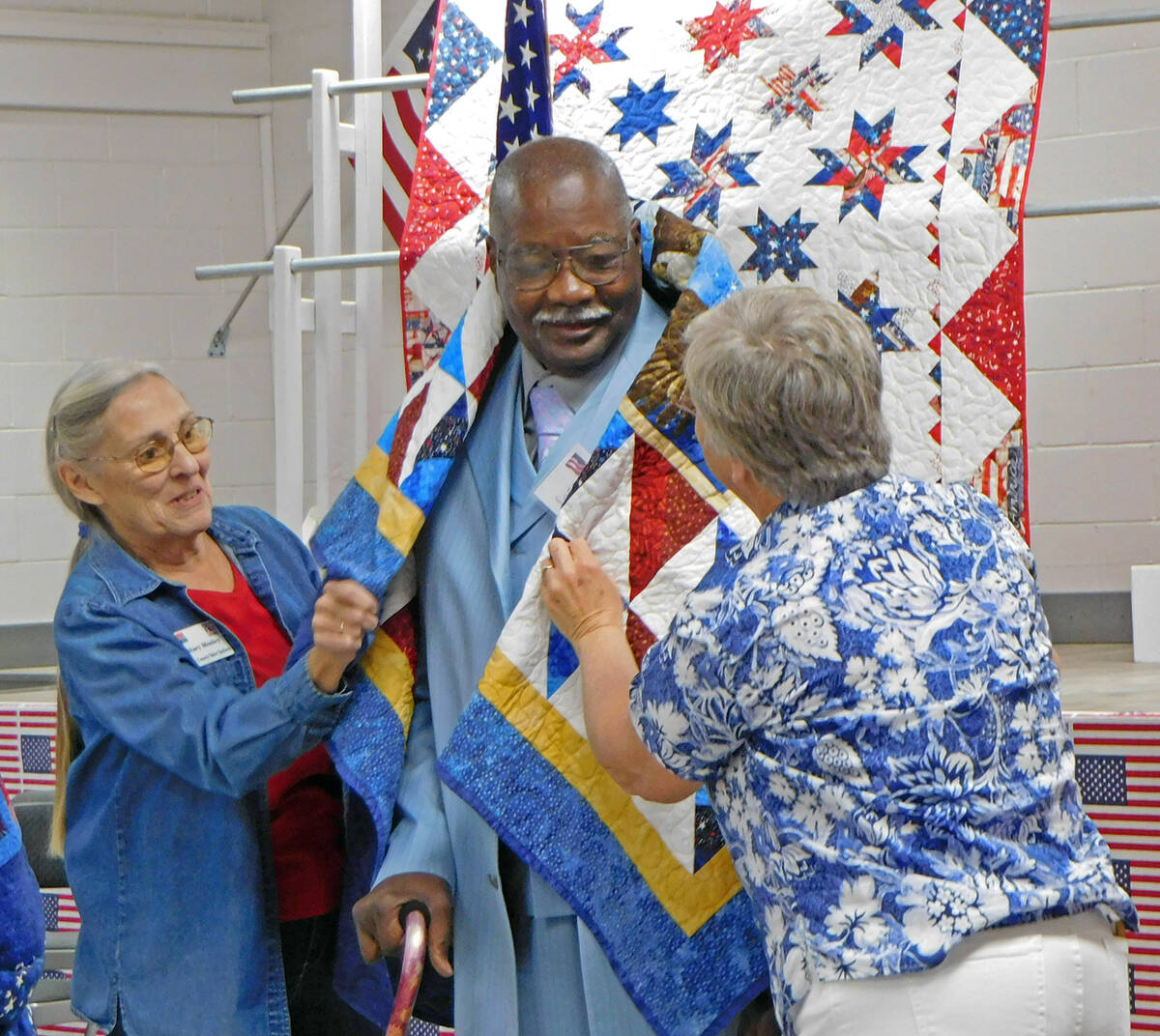 Robin Hebrock/Pahrump Valley Times Two Nye County Valor Quilters volunteers drape a Quilt of Va ...