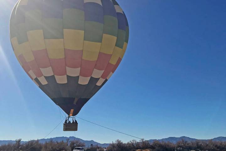 Robin Hebrock/Pahrump Valley Times A hot air balloon hovers over Nature Health Farms while a tr ...