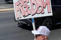 Bill Newyear/Special to the Pahrump Valley Times A Trump supporter sits in the sun at the corne ...