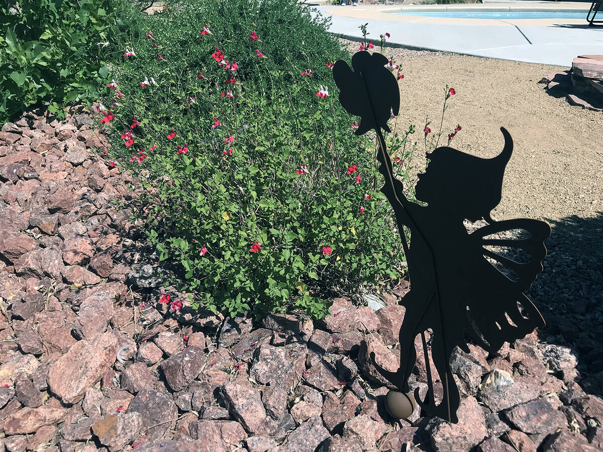 Robin Hebrock/Pahrump Valley Times A flowering bush and a metal fairy statue nestle in a bed of ...