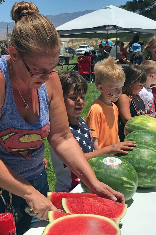 Robin Hebrock/Pahrump Valley Times Pahrump Holiday Task Force member Nichole Walters slices wat ...