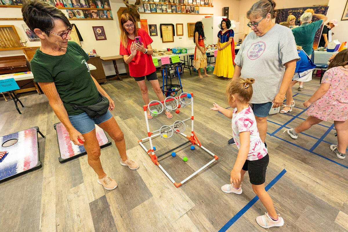 John Clausen/Pahrump Valley Times Playing a ball-toss game, a little girl successfully makes he ...