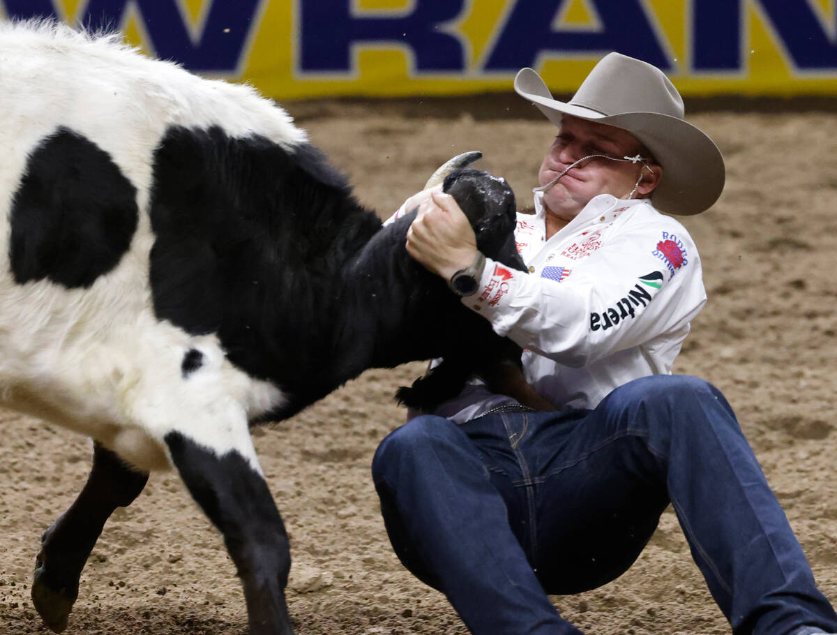 Dakota Eldridge wrestles a steer to the ground while he competes in steer wrestling on day six ...