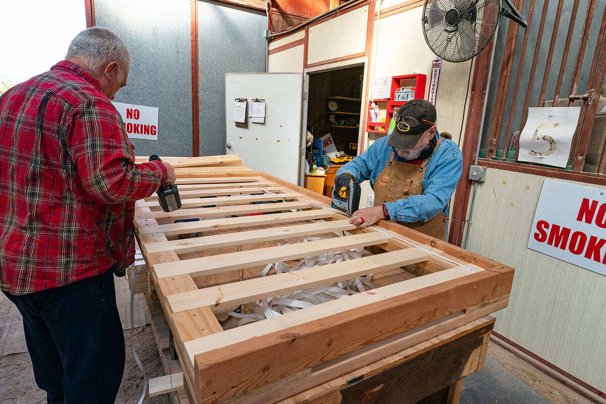 John Clausen/Pahrump Valley Times A couple of Winter Bed Build volunteers work on a bed frame. ...