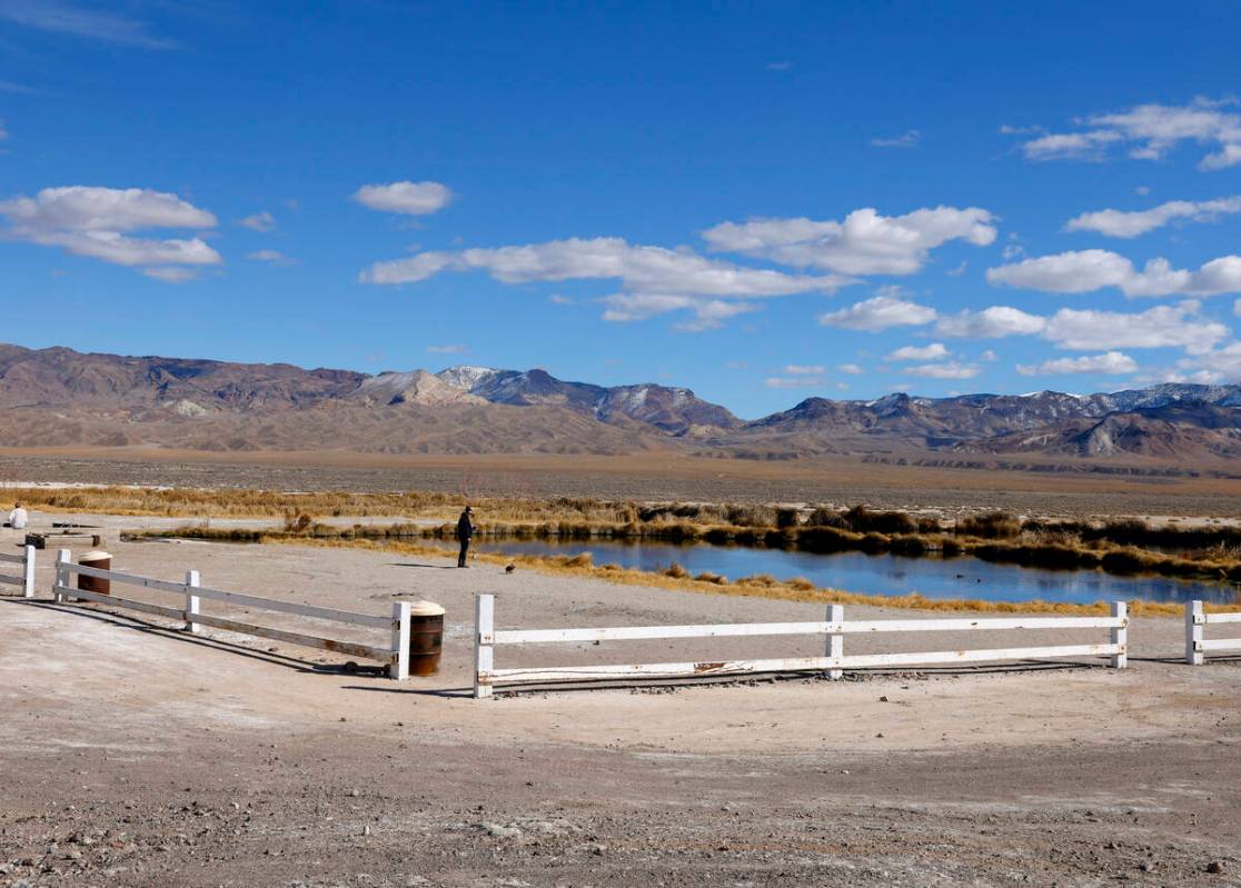 A woman stands at a pond formed from an old oil well project near the Rhyolite Ridge lithium-bo ...