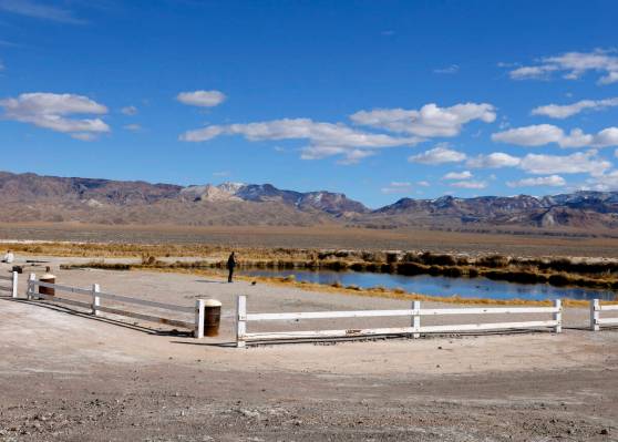 A woman stands at a pond formed from an old oil well project near the Rhyolite Ridge lithium-bo ...
