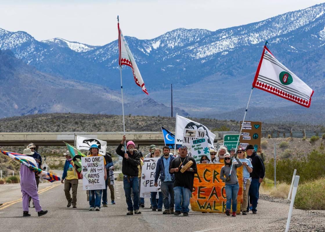 Members of the Nevada Desert Experience sacred peace walk make their way down to the entry of t ...