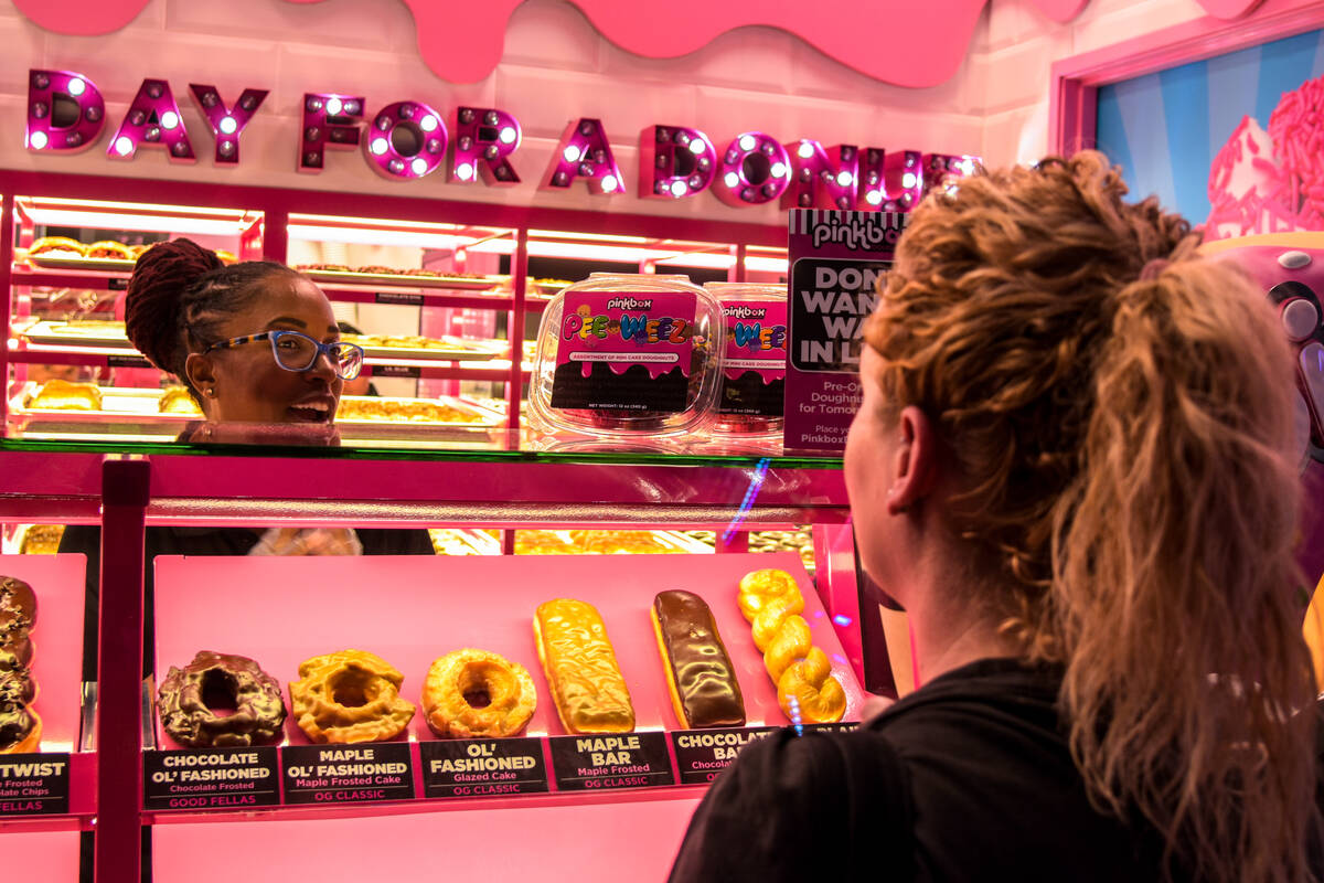 The first batch of customers are ordering at the grand opening of the Pinkbox Doughnuts shop lo ...