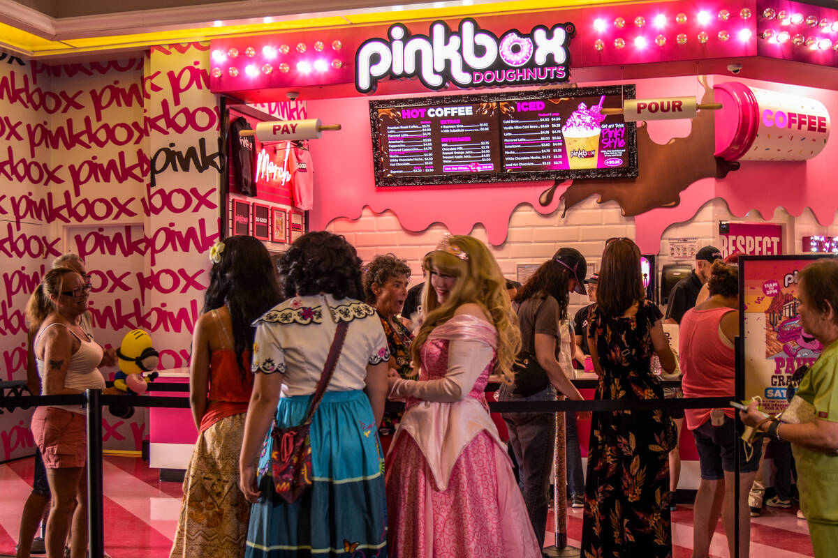 The first batch of customers are ordering at the grand opening of the Pinkbox Doughnuts shop lo ...