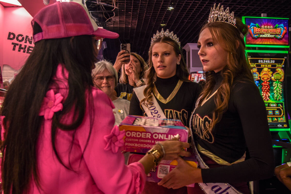 Judith Perez Siegel (left) hands Lucy Smith and Tayela Brown boxes of doughnuts at the grand op ...