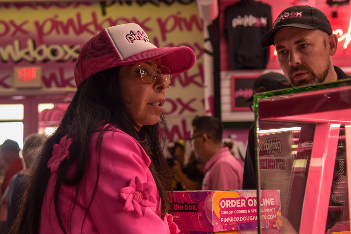 Judith Perez Siegel (left) waits to hand more boxes of doughnuts to the attendees of the grand ...