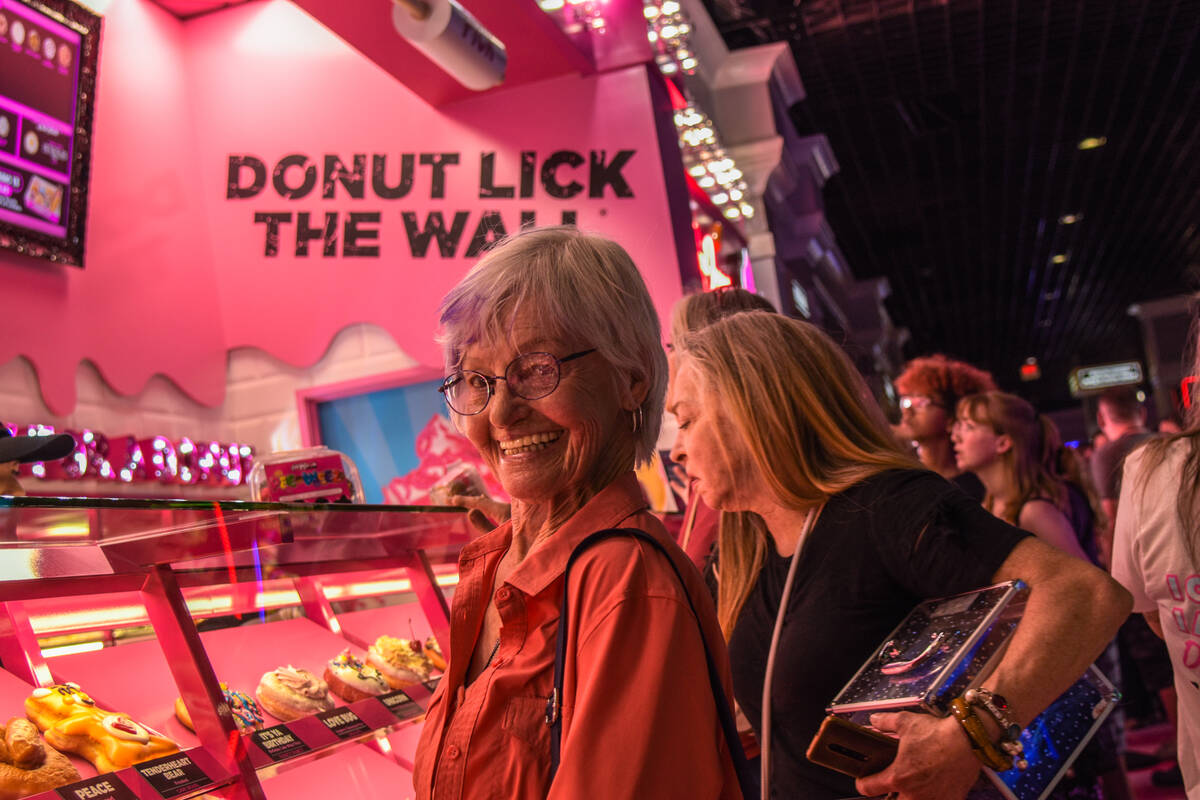 The first customer at the grand opening of the Pinkbox Doughnuts shop located inside the Pahrum ...