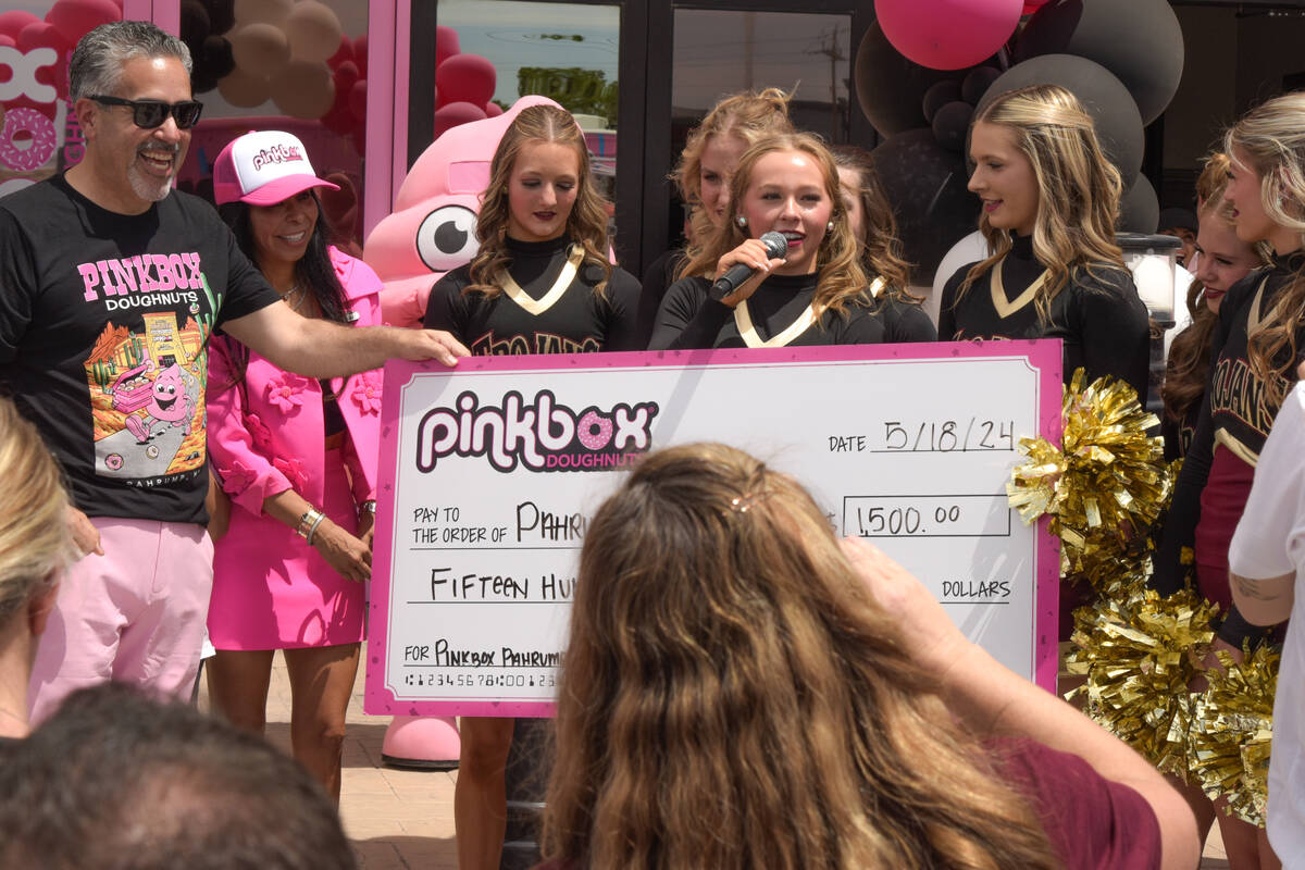 Peter Guzman (left) hands a check to the Pahrump Valley high school for $1,500 at the grand ope ...