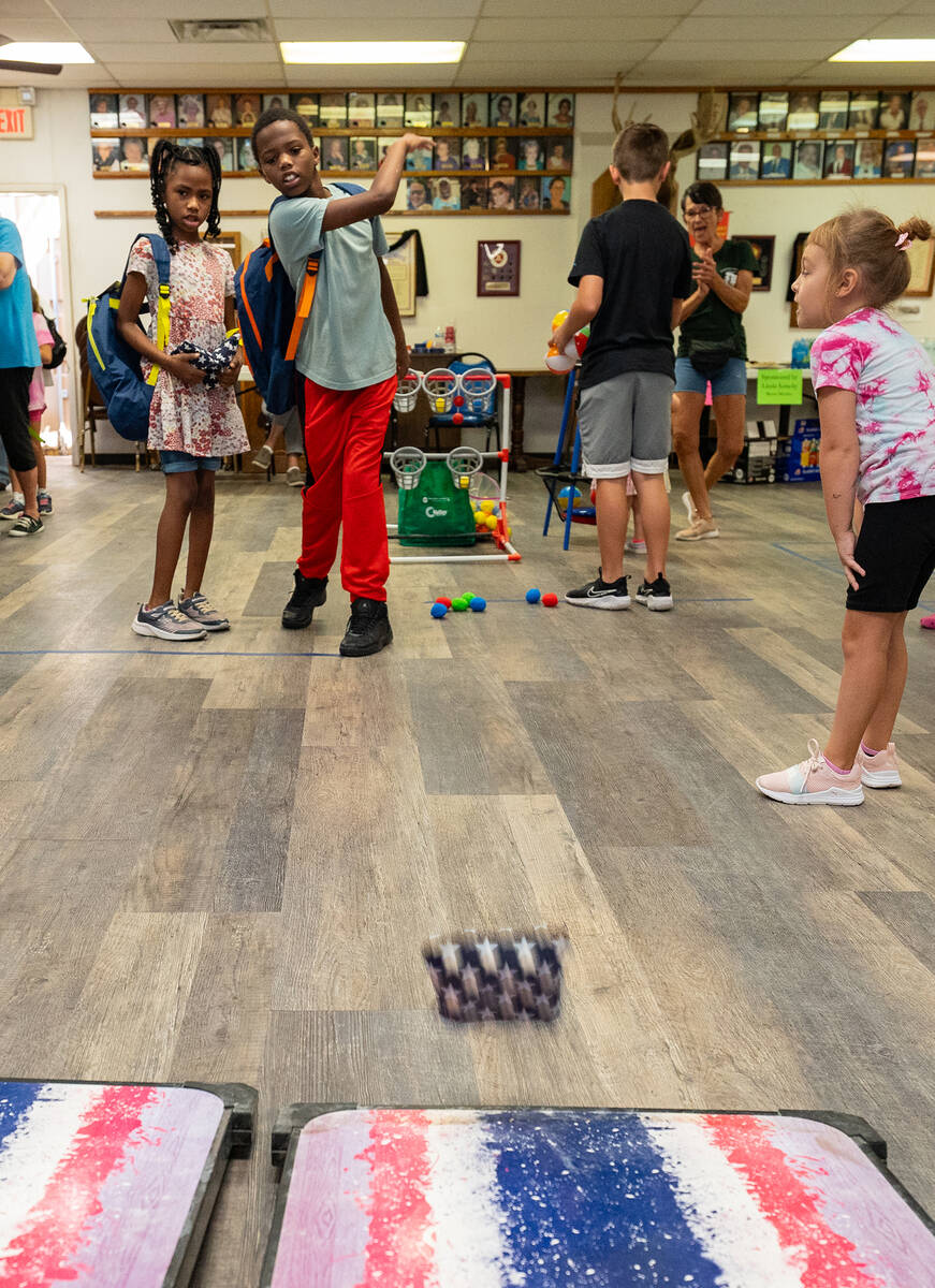 John Clausen/Pahrump Valley Times With great aim, a young boy tosses a bean bag into the corn h ...