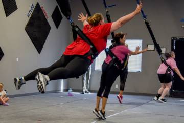 Anissa McClain, Fitlife Bungee member, jumps in the air while attached to a bungee harness for ...