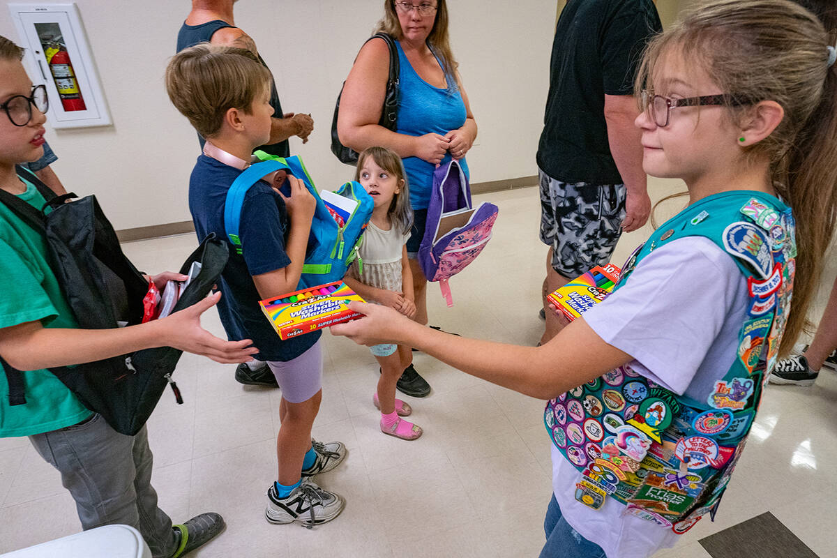 John Clausen/Pahrump Valley Times A youngster with the Girl Scouts hands colored pencils to a f ...