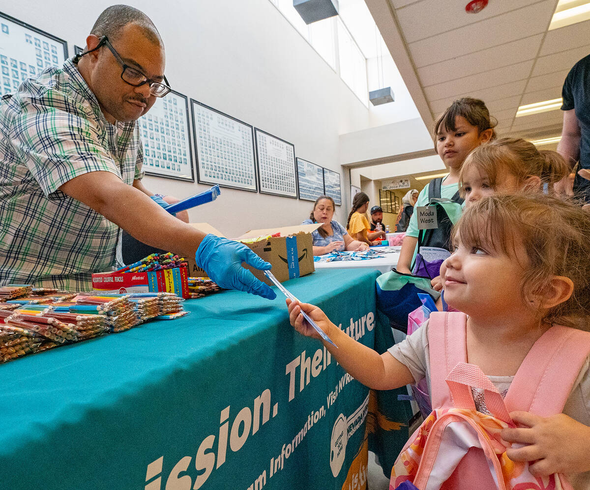 John Clausen/Pahrump Valley Times With a big grin, a young girl grabs supplies from a volunteer ...