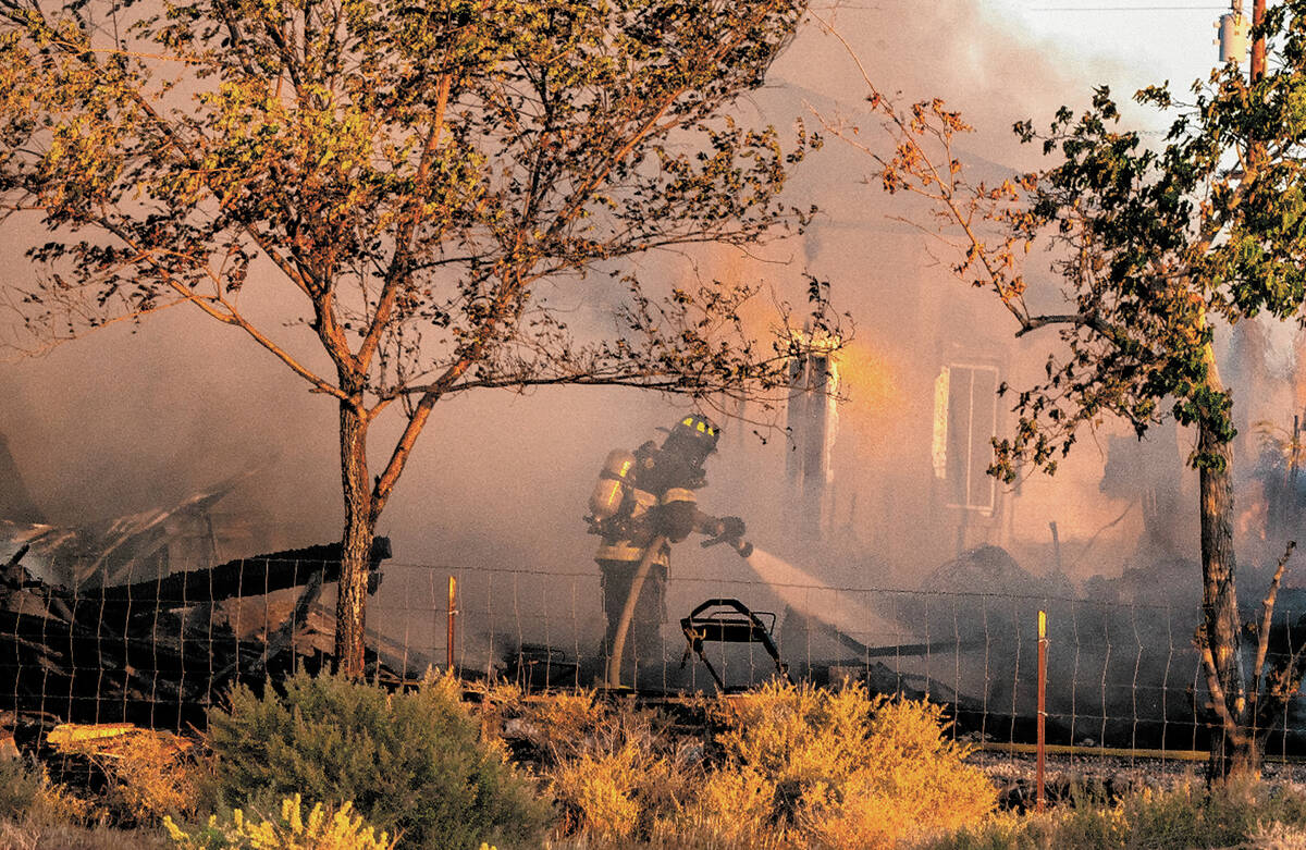 John Clausen/Pahrump Valley Times Crews fought through heavy smoke in a fire that destroyed a h ...