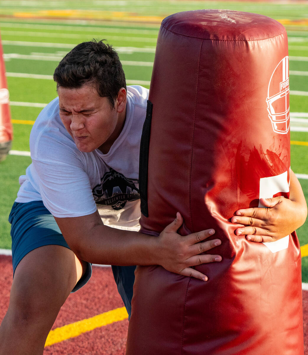 Pahrump Valley high school student athlete takes down a tackle dummy on the football field on T ...